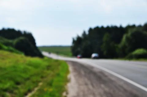 Blurred road background. No focus, cars Road and trees along the road. Stock Photos