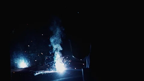 Blurred scene of industrial worker welding metal causing lots of spark Stock Footage 102570546