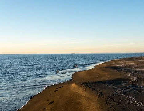 Blurred seaside background, blue sea and black sand beach, scenery background Stock Photos