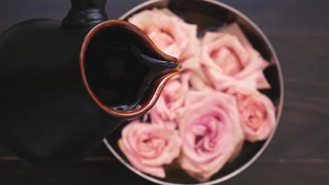 Blurred selective focus top view water pours in a bowl with soft pink roses on a Stock Footage 132768845