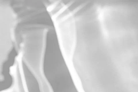 Blurred shadow and light caustic effect on a white wall Stock Photos