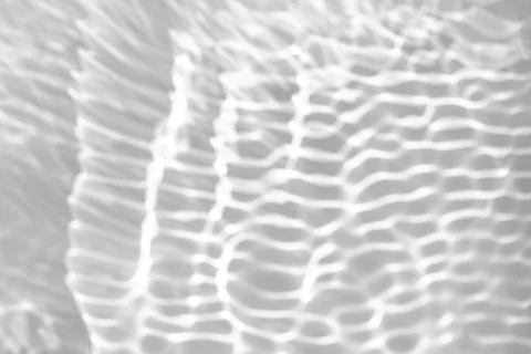 Blurred shadow and light caustic effect on a white wall Stock Photos