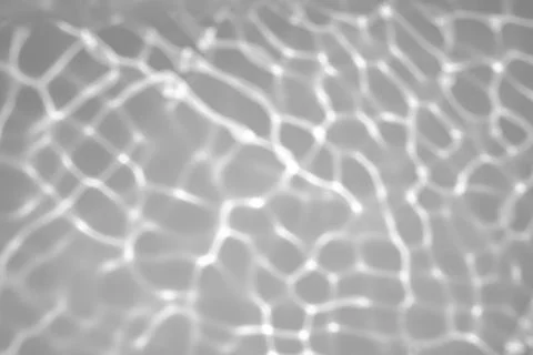 Blurred shadow and light caustic effect on a white wall Stock Photos