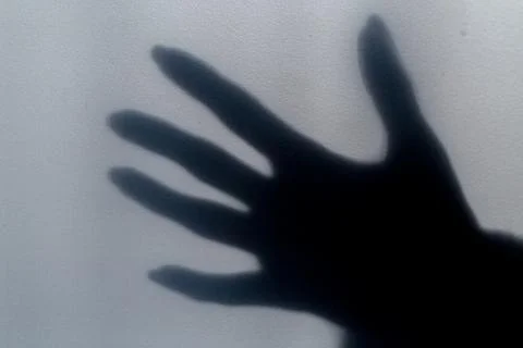 A blurred shadow of a hand on a painted wall, the shadow of a woman's hand Stock Photos