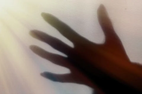 A blurred shadow of a hand on a painted wall, the shadow of a woman's hand Foto stock