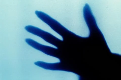 A blurred shadow of a hand on a painted wall, the shadow of a woman's hand Stock Photos