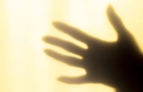 A blurred shadow of a hand on a painted wall, the shadow of a woman's hand Stock Photos