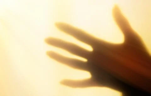 A blurred shadow of a hand on a painted wall, the shadow of a woman's hand Stock Photos