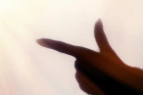 The blurred shadow of the index finger on the painted wall, the shadow of the Stock Photos