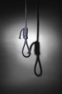 Blurred shadow of the loop of the gallows on the light wall, darkness, reduce Stock Photos