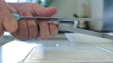 Blurred Shooting with a Butcher Sharping the Knives. One Person in the Kitchen Stock Footage 258029527