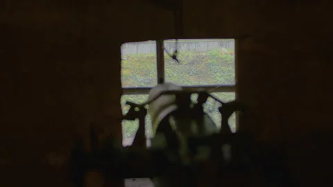 A blurred silhouette of a machine gun pointed at the embrasure in the wall. Stock Footage 305108447