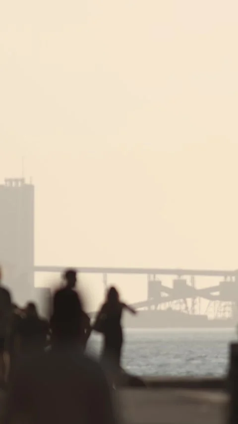Blurred silhouettes of people walking along the embankment near the seaport at Stock Footage 330051690