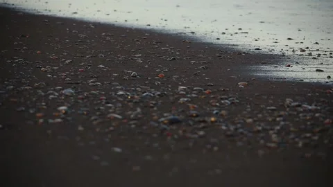 Blurred soft foamy waves washing pebbled beach on sunset foamy sea water waves Stock Footage 254343739