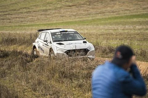 Blurred spectator in foreground while photographing an Hyundai i20N Rally2 Stock Photos