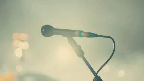 Blurred stage lights surround a microphone on a stand Foto stock