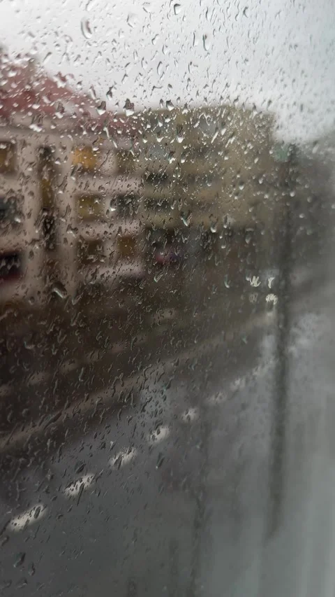 Blurred street view through rain-covered glass with glowing car lights. Vertical Stock Footage 294036953