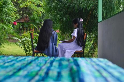 Blurred table foreground frames girls studying in garden Stock Photos