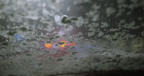 Blurred traffic lights through snowy frosted windshield creating a winter amb Stock Footage 309885367