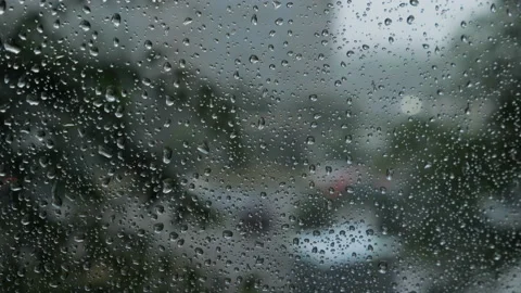 Blurred traffic view through a car windscreen covered in rain for background Stock Footage 97430351