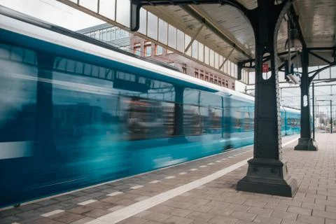 Blurred train motion with high speed at railway station Stock Photos