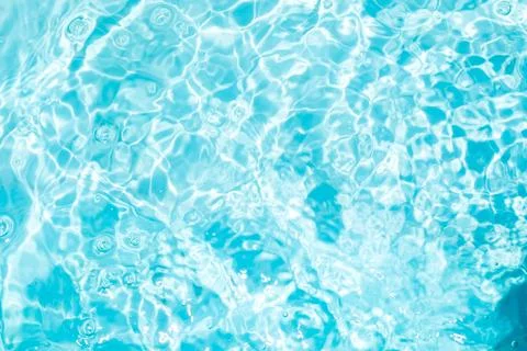 Blurred transparent blue colored clear calm water surface texture with spla.. Stock Photos