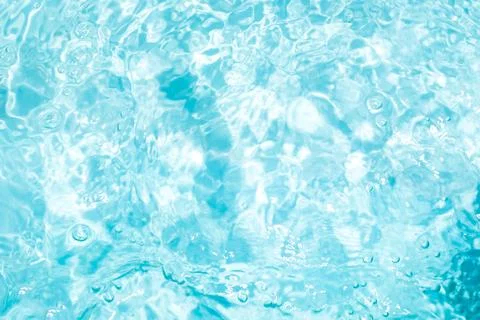 Blurred transparent blue colored clear calm water surface texture with spla.. Stock Photos