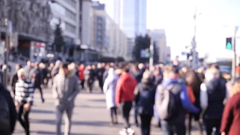 Blurred unrecognizable crowd of people walking the city road at a green traffic Video stock 106734028