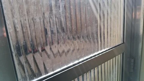 Blurred vertical stripes seen through a dusty textured glass window pane Stock Photos