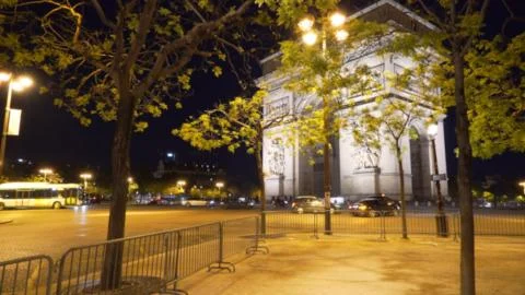 Blurred view of Arc de Triomphe at night near busy road in Paris, France Stock Photos