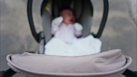 Blurred view of a baby resting in a stroller while on a walk on the street Video stock 316637282