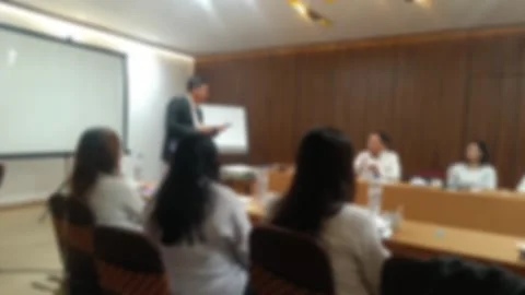 A blurred view of A business meeting in progress with a presenter at the front Stock Footage 340533744