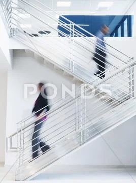 Blurred View Of Business People Climbing Office Staircase