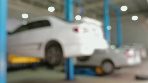 Blurred view of car repair workshop with vehicles lifted on hydraulic Video stock 281666450