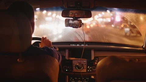 Blurred view of city through windshield of moving car and through working wipers Stock-Footage 105870600