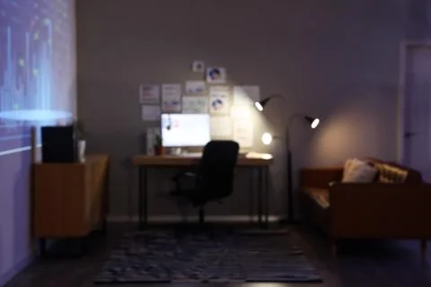Blurred view of dark data scientist's office with workplace, diagrams and glo Stock Photos