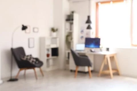 Blurred view of data scientist's office with workplace, shelf units and armch Stock Photos