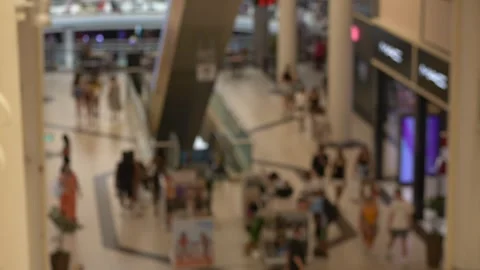 Blurred view inside shopping mall with people, escalators, and store windows Video stock 317323945