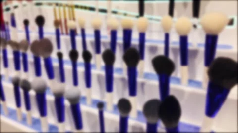 Blurred view many makeup brushes with blue handles arranged tiered display stand Vidéo 344094857