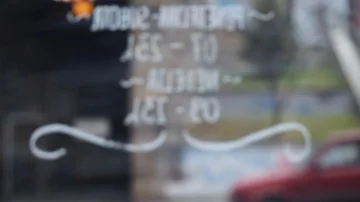 Blurred view outside from a coffee shop through a glass door Video stock 85616033
