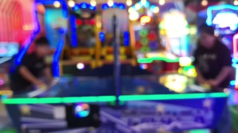 Blurred view of people playing air hockey in an arcade. 库存影片 336319598