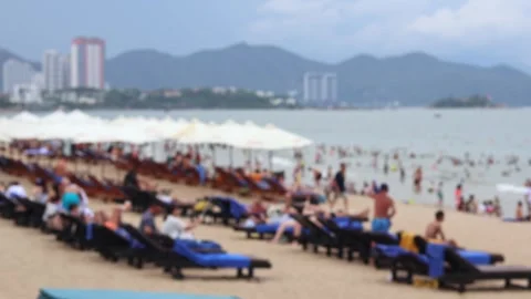 Blurred view of people relaxing on a sandy beach on the seashore Stock Footage 312225071