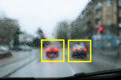 Blurred view of road with scanner frames on cars through wet automobile windo Stock Photos