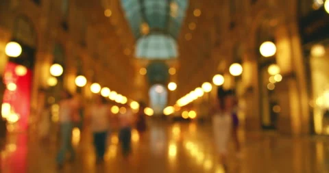 Blurred view of shopping mall gallery with people walking and warm glowing light Stock Footage 320089014