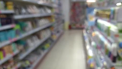 Blurred view of a store aisle with various products on shelves Stock Photos