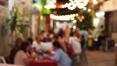 A blurred view of a street restaurant in the evening, decorated with garlands Stock Footage 324874156