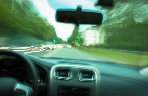 Blurred view through the windshield of a fast moving car Stock Photos