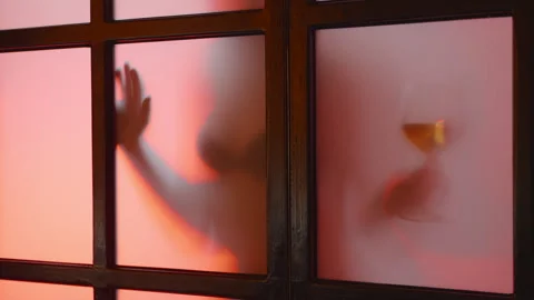 Blurred view of unrecognized nude model attracting someone with a glass of wine Stock Footage 258282354