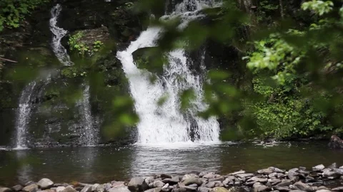 Blurred view of a waterfall through the trees. Pristine waterfall, natural Stock Footage 99605844