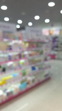 Blurred view of a well-lit store aisle with colorful products on shelves Stock Photos